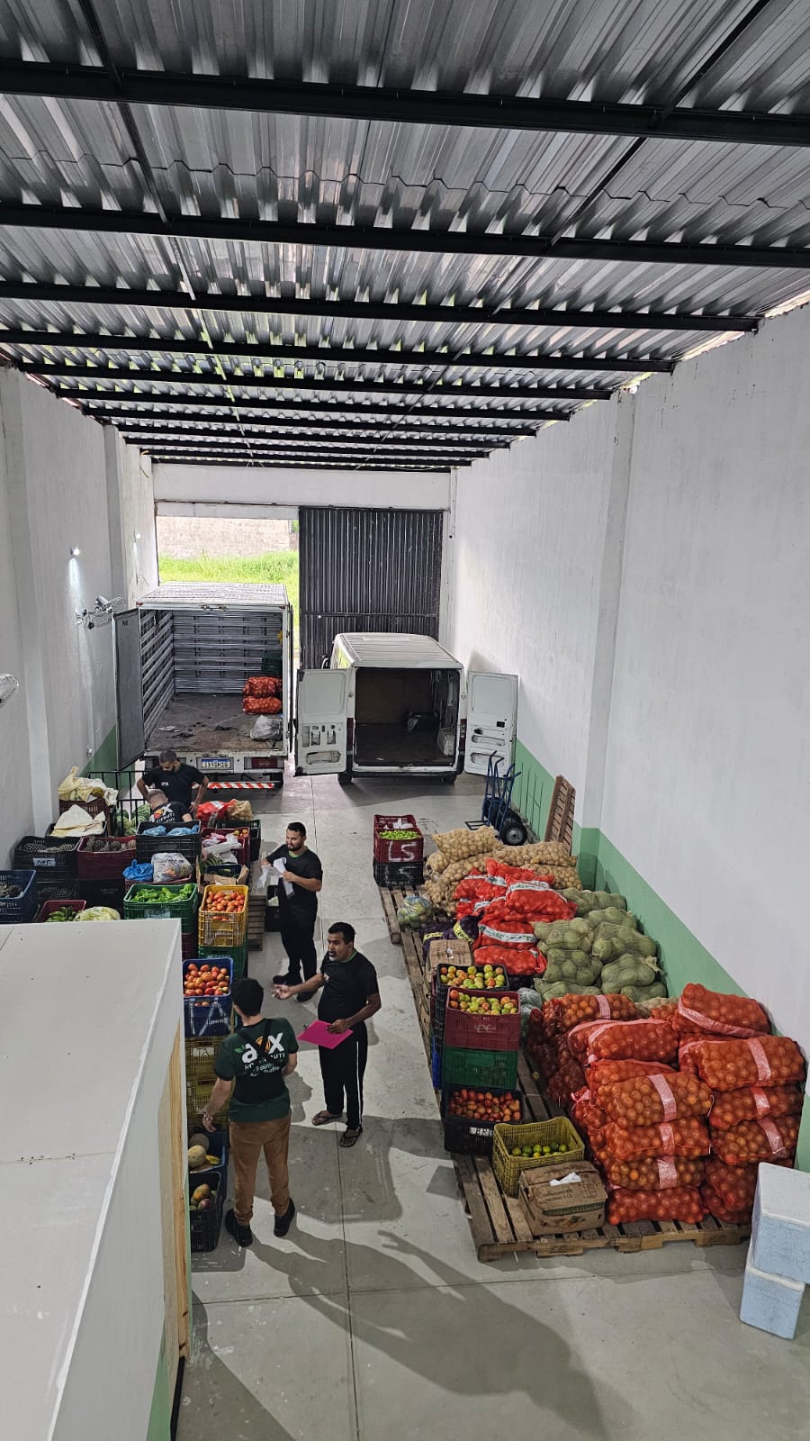 Caixas de frutas, legumes e verduras frescos organizados no centro de distribuição